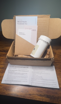 Photo of opened Hims box with contents and prescription information
