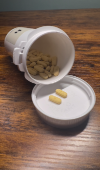Photo of opened Hims prescription pill bottle and contents