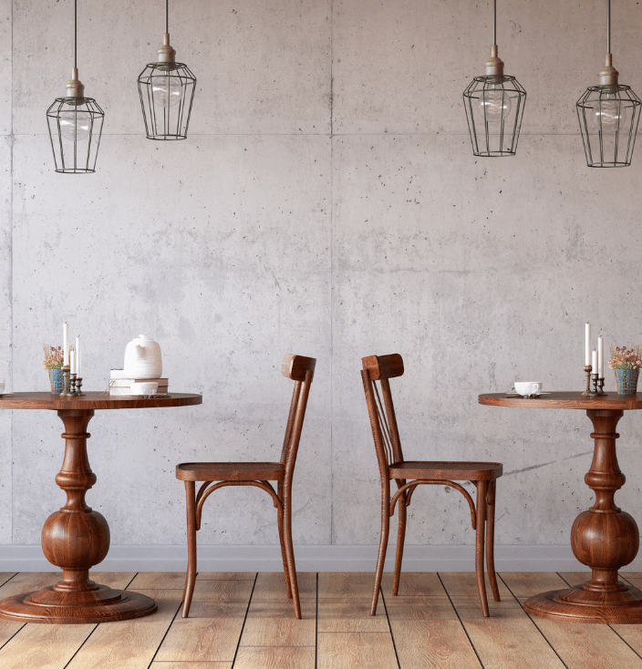 Two sets of tables and chairs against a grey wall
