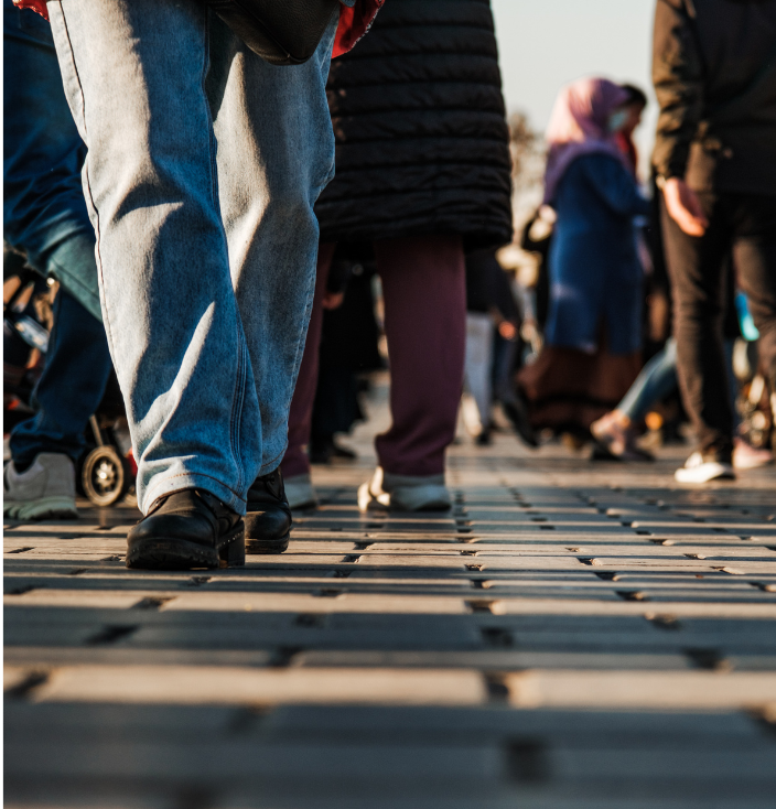 The bottom of people's legs walking on the sidewalk